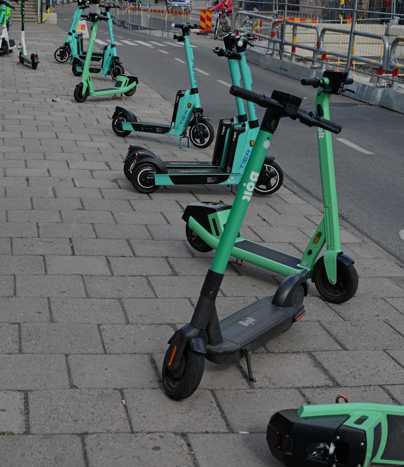 STOCKHOLM, SWEDEN - August 15, 2021: Electric scooters parked on pavement is Stockholm, Sweden.  The...