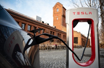 22 January 2022, Berlin: Tesla brand vehicles are parked at a series of Tesla fast-charging stations...