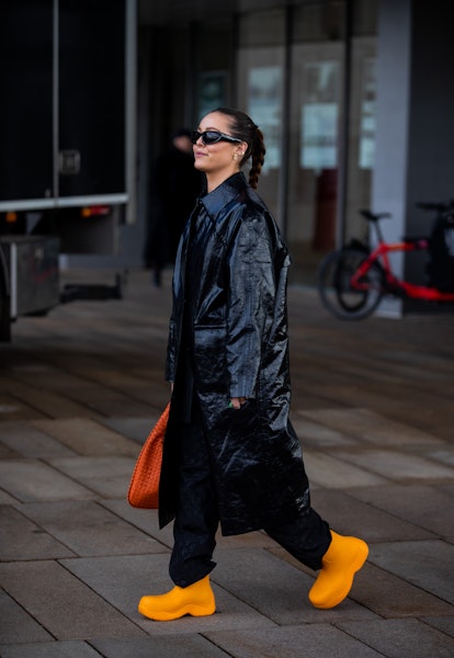 COPENHAGEN, DENMARK - FEBRUARY 02: A guest wearing black coat, orange bag, boots seen outside Saks P...