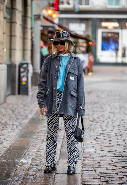 COPENHAGEN, DENMARK - FEBRUARY 01: A guest is seen wearing bucket hat, denim jacket, black white zeb...