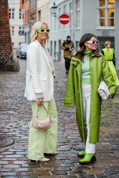 COPENHAGEN, DENMARK - FEBRUARY 01: Guests seen wearing green coat, Bottega Veneta bag, white pants, ...