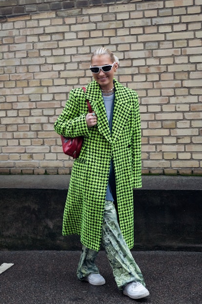 COPENHAGEN, DENMARK - FEBRUARY 03: Maria Wos wearing bright green long coat, red bag and transparent...
