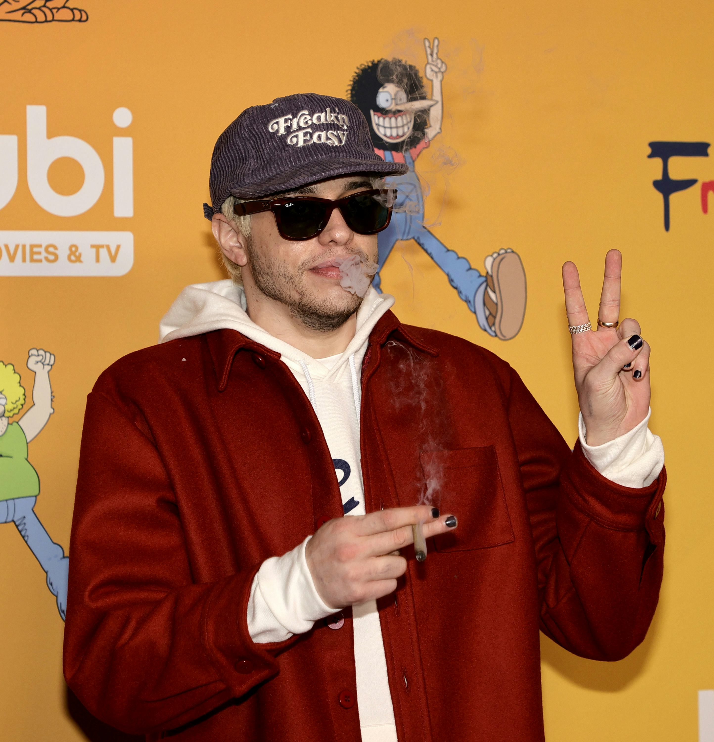 LOS ANGELES, CALIFORNIA - DECEMBER 06: Pete Davidson smokes as he arrives at TUBI's "The Freak Broth...