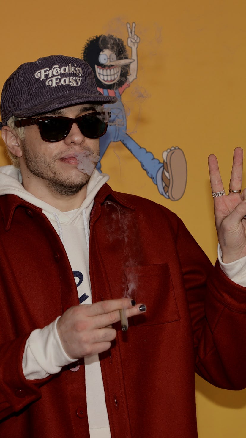 LOS ANGELES, CALIFORNIA - DECEMBER 06: Pete Davidson smokes as he arrives at TUBI's "The Freak Broth...