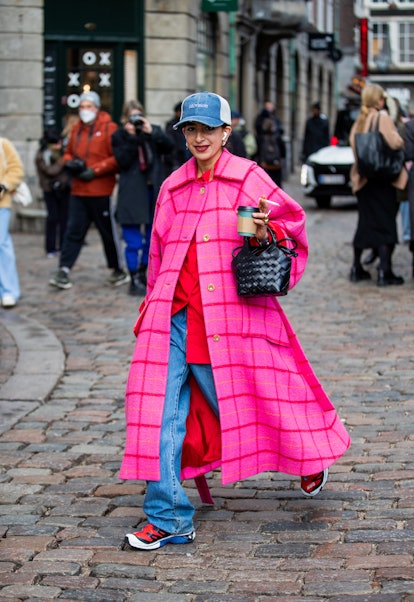COPENHAGEN, DENMARK - FEBRUARY 02: A guest is seen wearing cap, pink checkered coat, black bag outsi...