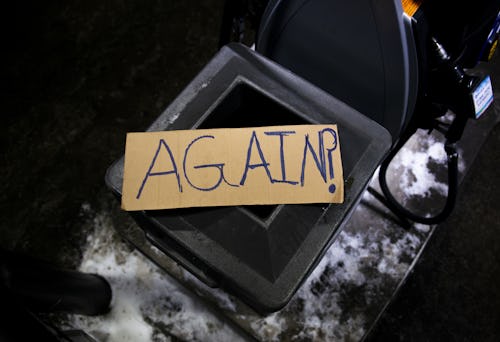 MINNEAPOLIS, MN - DECEMBER 31: A cardboard sign stating Again? sits on a trash can during a vigil fo...