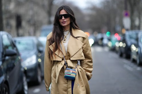 PARIS, FRANCE - JANUARY 23: A guest wears black sunglasses, gold earrings, a gold large double chain...