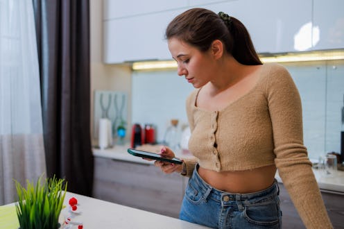 Young Caucasian White attractive, long-haired woman in the kitchen.