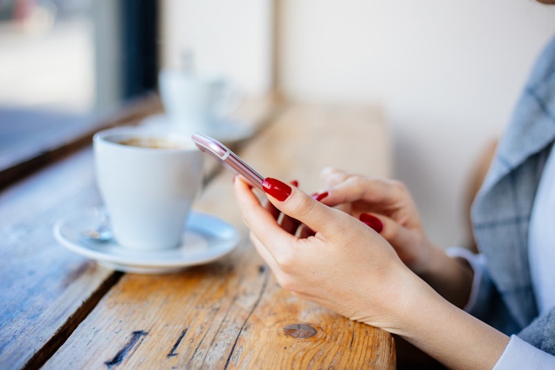 Cheerful Woman Using Phone At Cafe