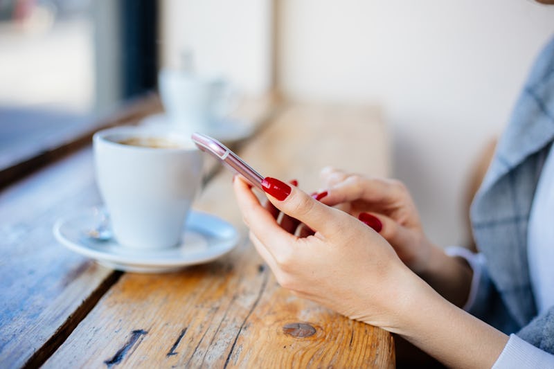 Cheerful Woman Using Phone At Cafe