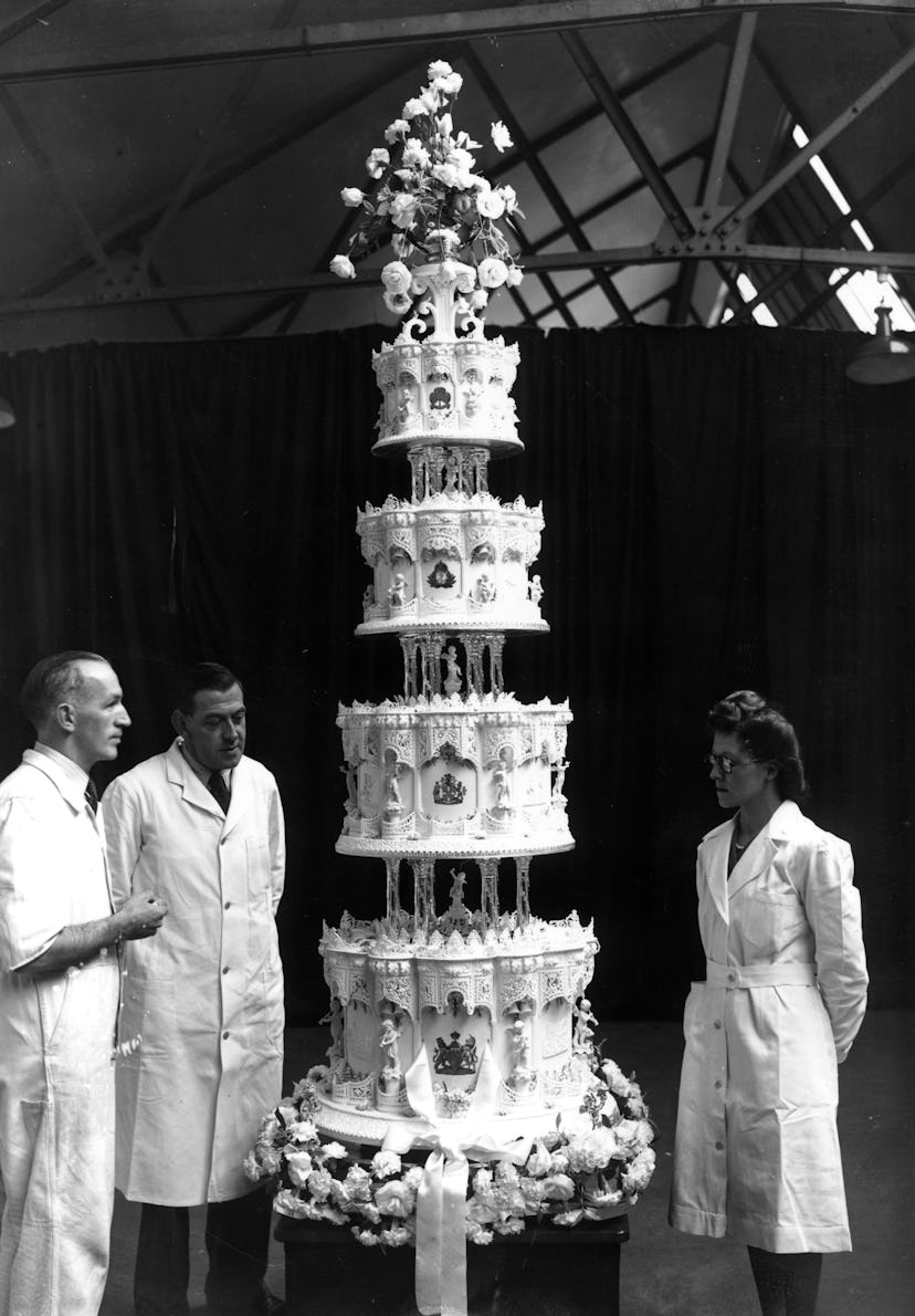 Mr Schur (centre), chief confectioner at McVitie and Price Ltd, standing next to the official cake f...