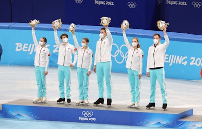 BEIJING, CHINA - FEBRUARY 07: Gold medalists Team ROC celebrate during the Team Event flower ceremon...