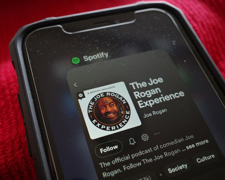 This illustration photo shows the Spotify page for "The Joe Rogan Experience" podcast displayed on a...