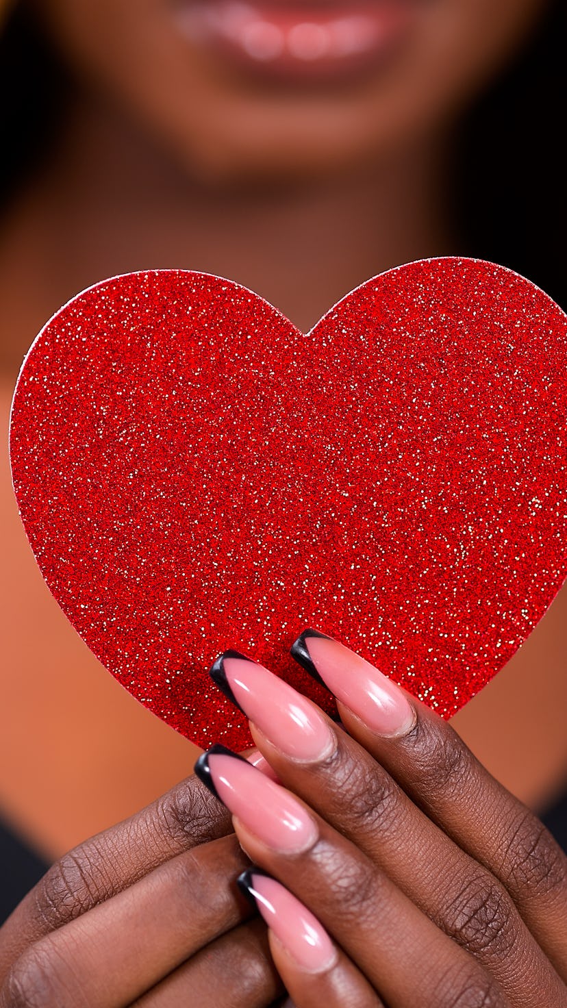 Afro woman holding shape of heart