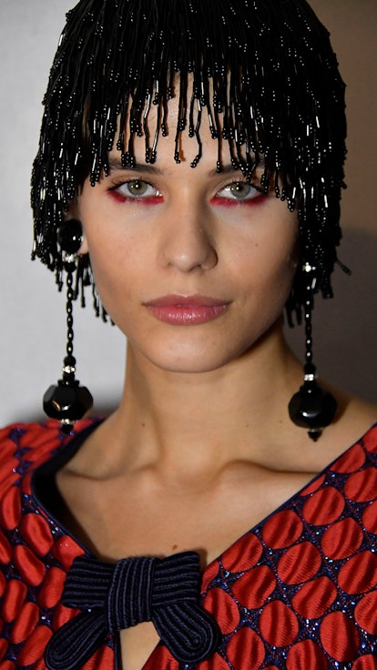 A model with under eye, red eyeshadow backstage during the Giorgio Armani Prive Haute Couture Spring...
