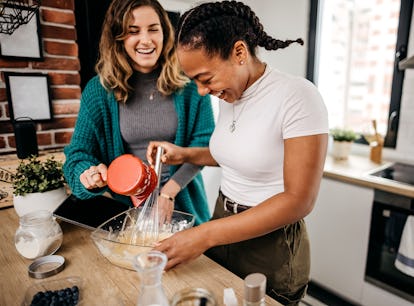 Two lesbian women prepare a delicious breakfast at home. American pancakes are on the menu