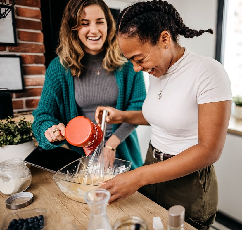 Two lesbian women prepare a delicious breakfast at home. American pancakes are on the menu