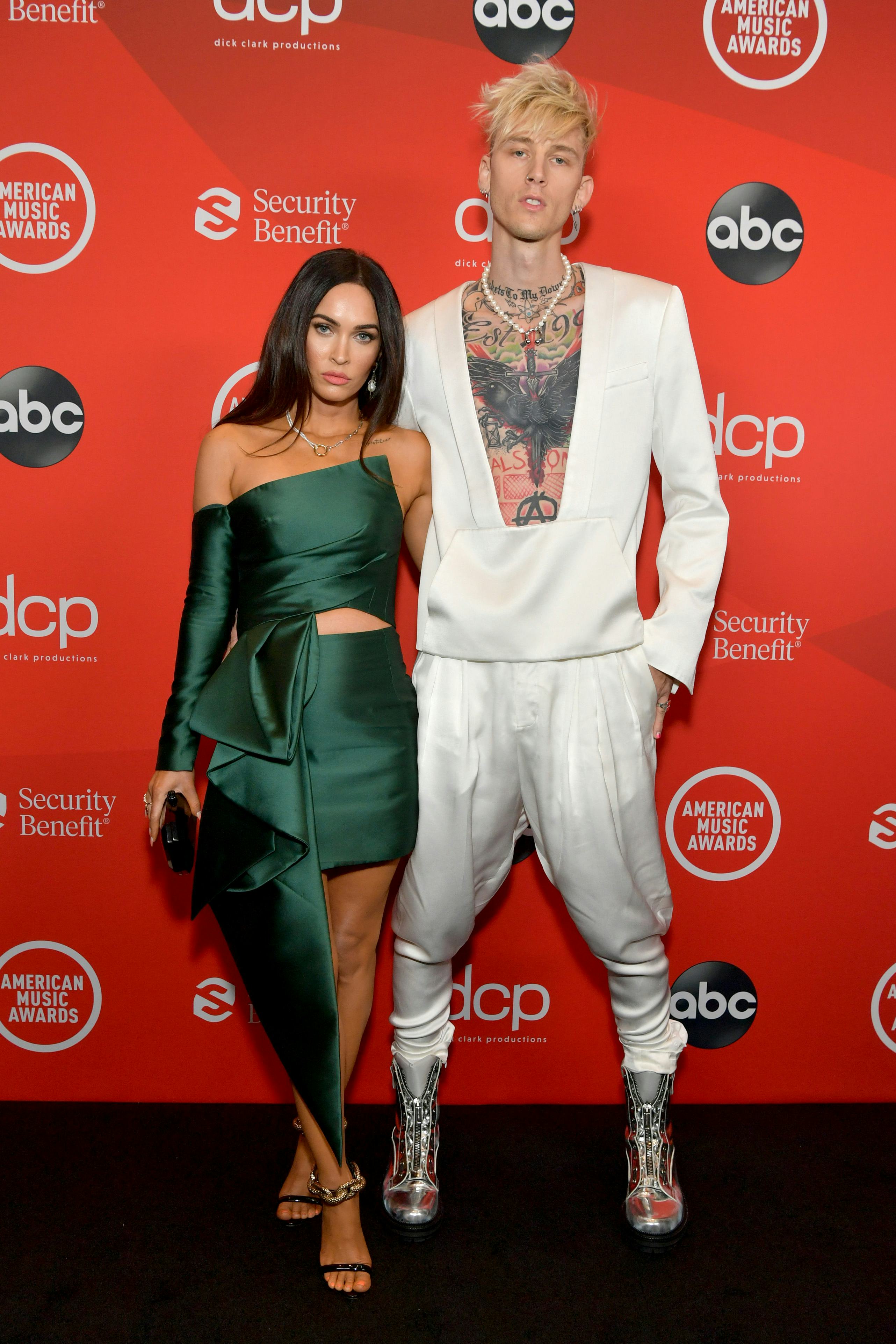 Megan Fox in a satin green minidress and Machine Gun Kelly in a white two-piece.