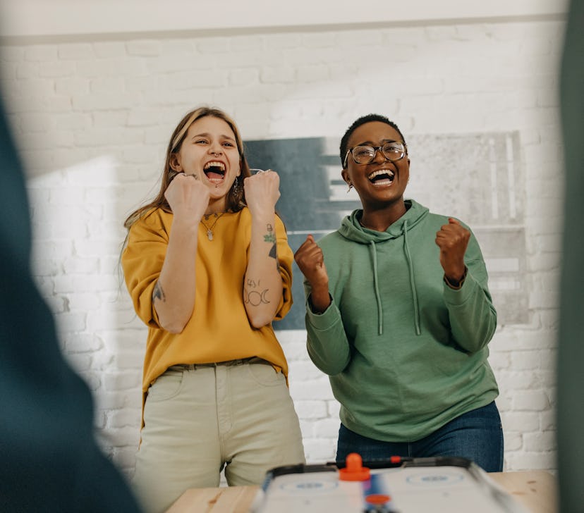 young women laughing together as the discuss the most romantic day in march 2022 for their zodiac si...