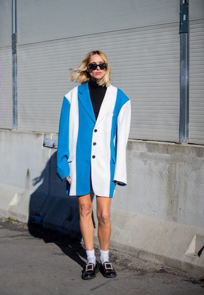 MILAN, ITALY - FEBRUARY 26: Candela Novembre seen wearing blue white striped oversized jacket, white...