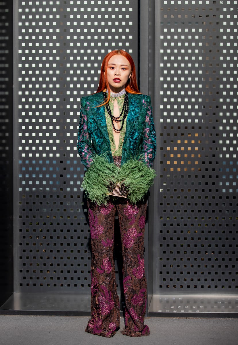 MILAN, ITALY - FEBRUARY 25: Niki Wu Jie seen wearing green blazer, red brown pants outside Gucci fas...