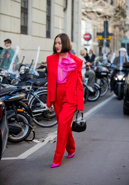 MILAN, ITALY - FEBRUARY 25: Tiffany Hsu seen wearing red suit, pants, pink blouse, black bag, heels ...