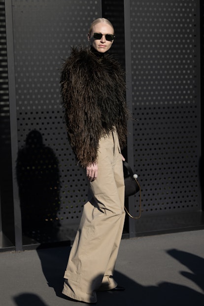 MILAN, ITALY - FEBRUARY 25: A guest is seen ahead of the Gucci fashion show wearing a brown furry ja...