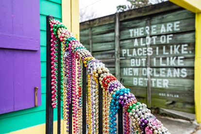 The hand rail of a home in the Bywater is wrapped with Mardi Gras beads. Why do women flash for bead...