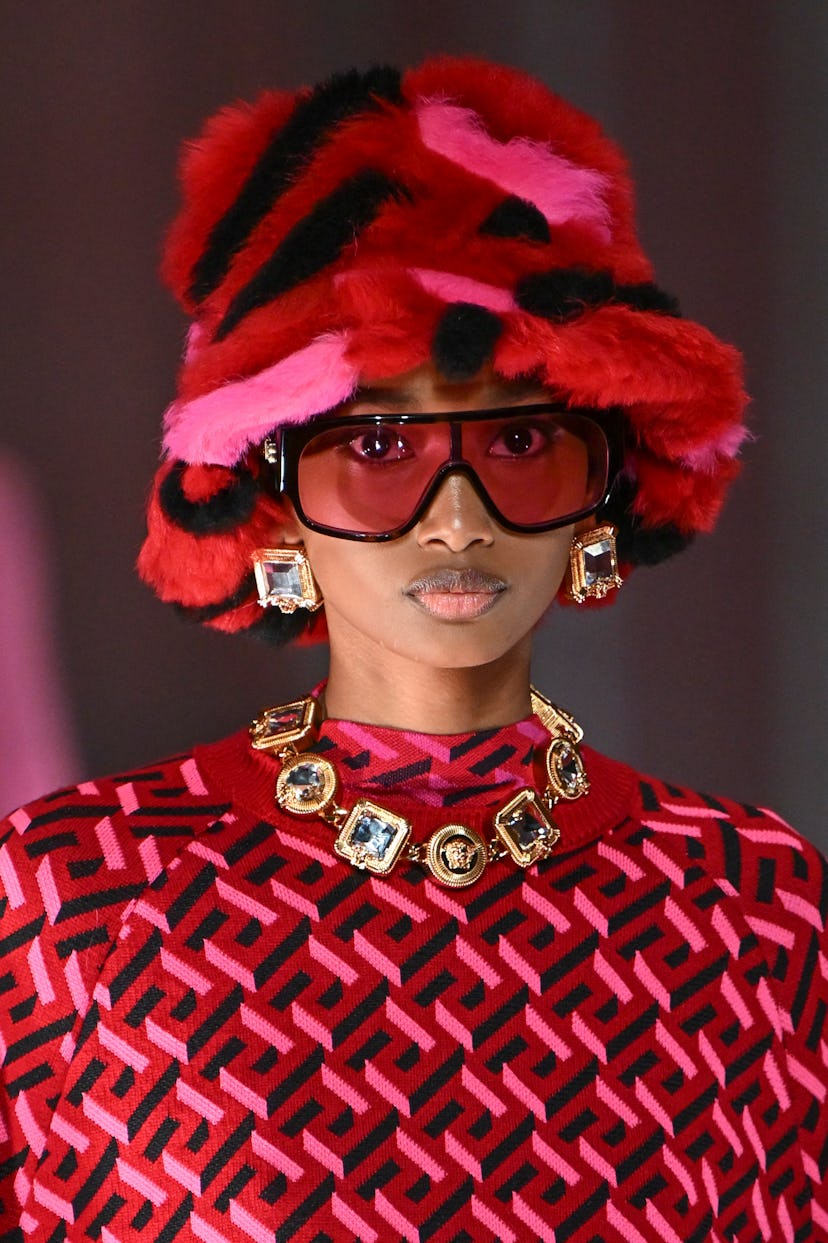 At Milan Fashion Week F/W 2022, a model walks down the Versace runway..