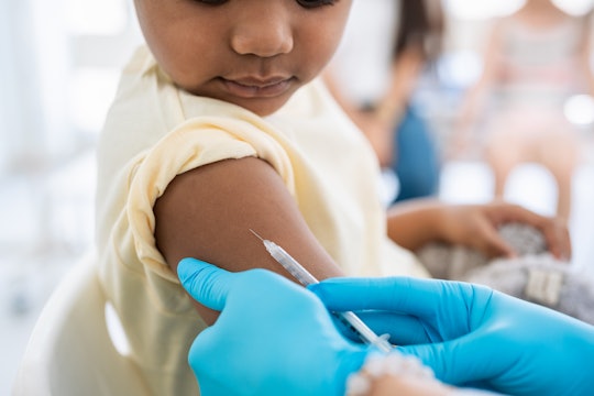 Immunisation. Protecting children from diseases. Close-up nurse in medical gloves giving injection t...