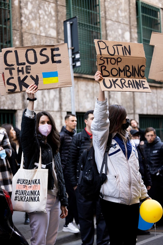 MILAN, ITALY - FEBRUARY 27: Anti-war protesters hold pro-Ukraine signs outside the Giorgio Armani fa...