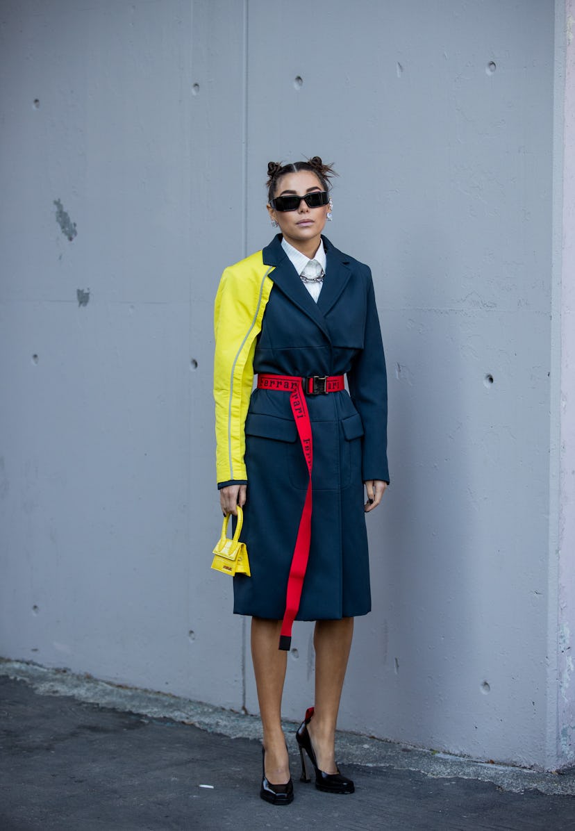 MILAN, ITALY - FEBRUARY 27: Karina Nigay seen wearing two tone yellow grey coat, red belt, yellow Ja...