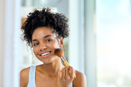 Shot of an attractive young woman applying makeup during her morning beauty routine