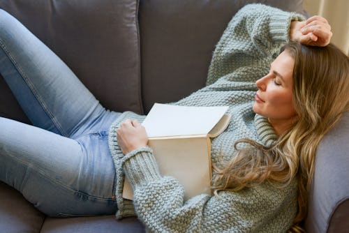 A woman naps on the couch with a book on her chest. Here's your daily horoscope for March 11, 2022.