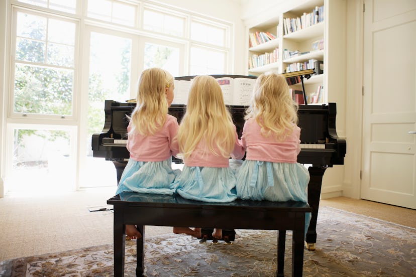 three girls playing piano
