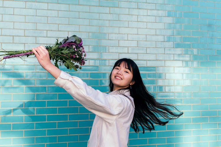 A young woman holding a bouquet of flowers, celebrating the spring equinox on March 20, 2022.