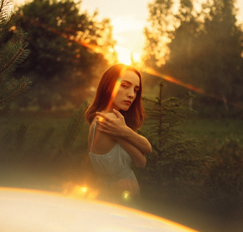 A young woman watching the sunrise, celebrating the spring equinox on March 20, 2022.