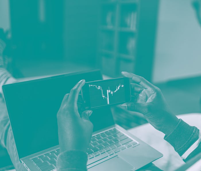 Man holding mobile phone and analyzing cryptocurrency trends