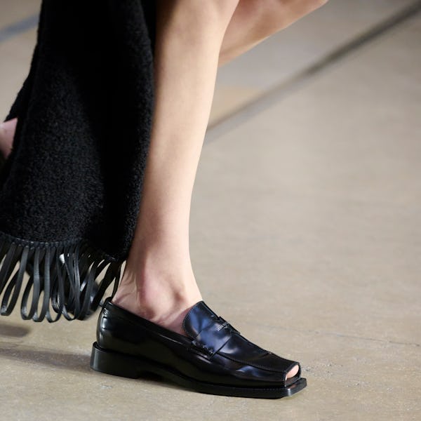 a model wearing black peep-toe loafers on the Louis Vuitton runway
