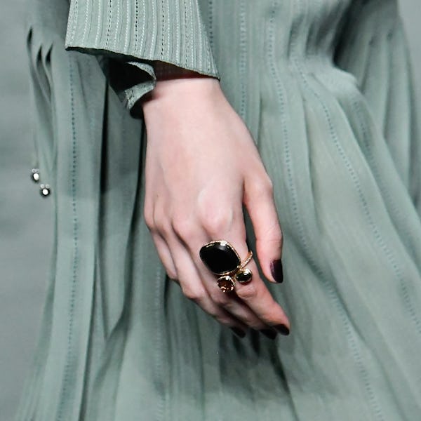 a model wearing a large gemstone ring on the Hermès runway