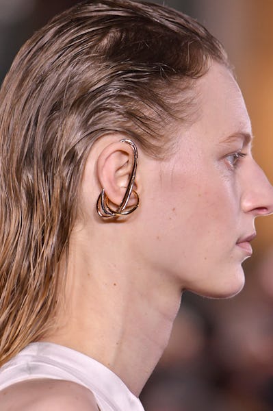 a model wearing a sculptural mixed metal earring by Cartier on the Sacai runway