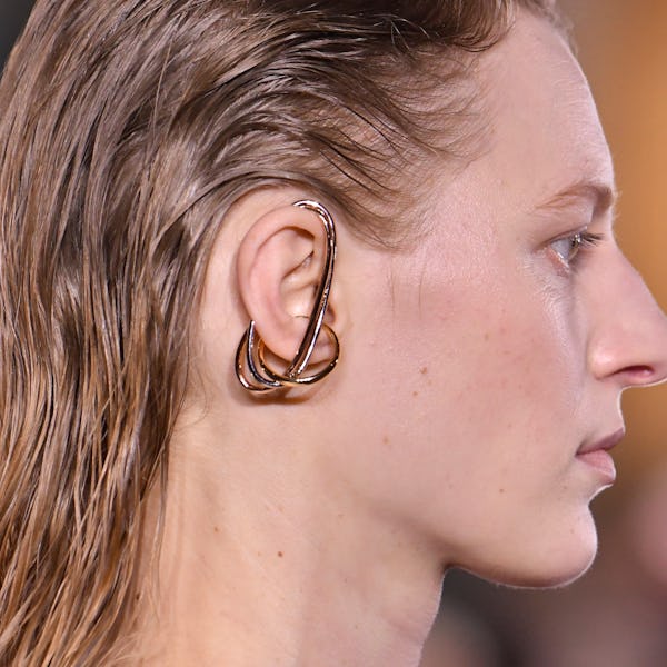 a model wearing a sculptural mixed metal earring by Cartier on the Sacai runway