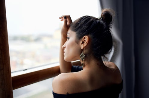 woman looking outside her window