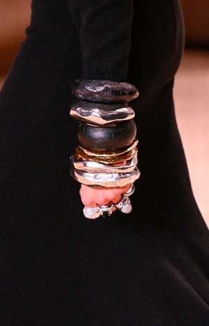a model wearing layered thick bangle bracelets on the Saint Laurent runway