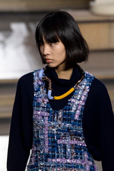 a model wearing a sculptural modular necklace on the Louis Vuitton runway