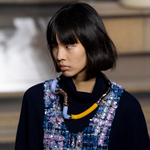 a model wearing a sculptural modular necklace on the Louis Vuitton runway