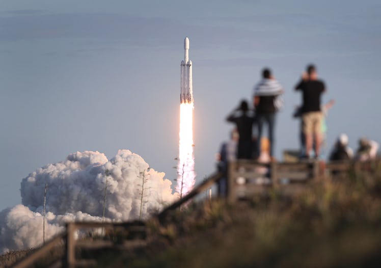 People watch as the SpaceX Falcon Heavy rocket lifts off from launch pad 39A at NASA’s Kennedy Space...