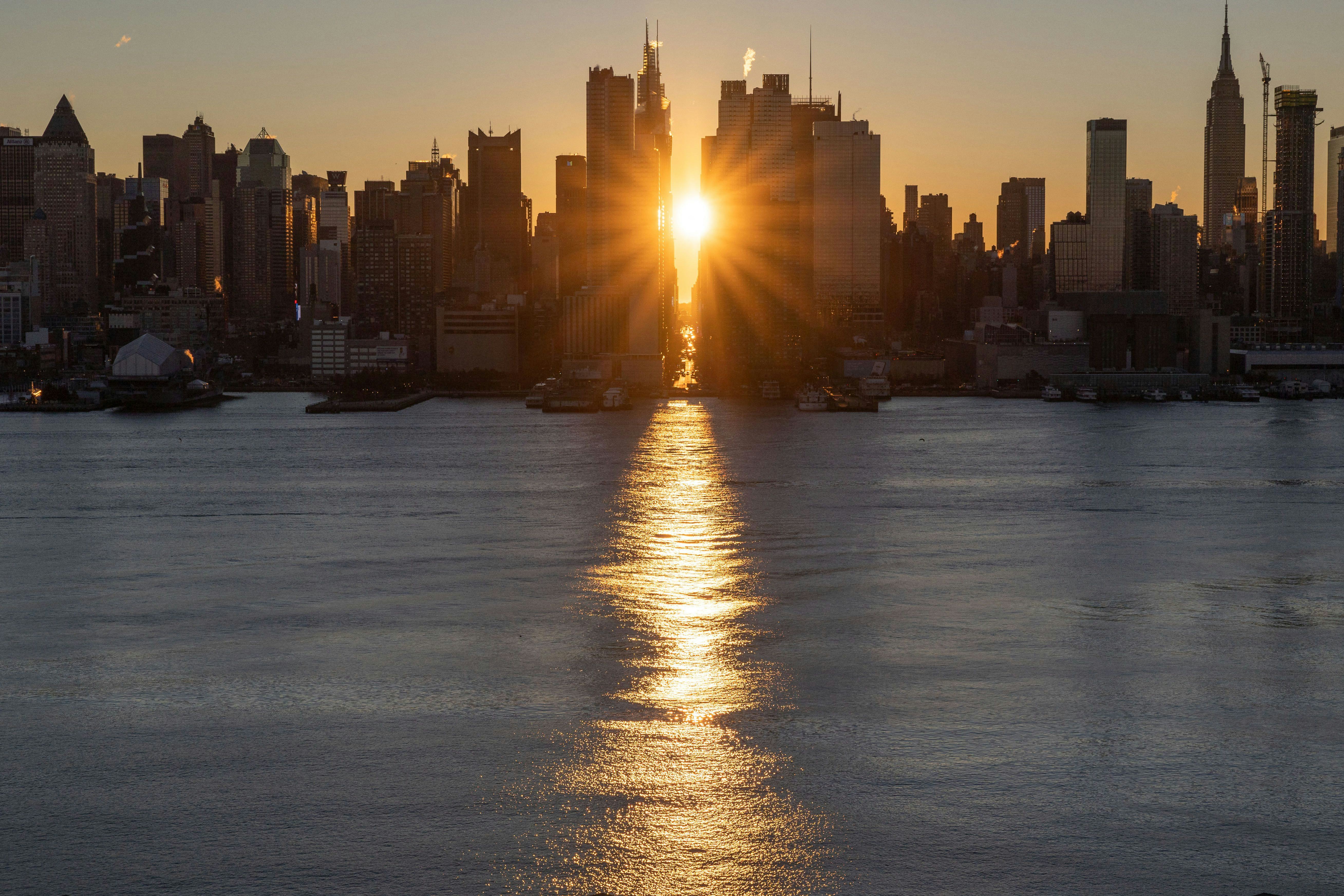 The sun rises above 42nd Street during a reverse 'Manhattanhenge' in New York, New York. The Senate ...