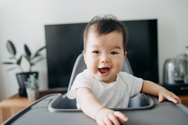 Adorable baby smiling joyfully on high chair