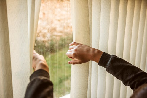 person peekig out the window